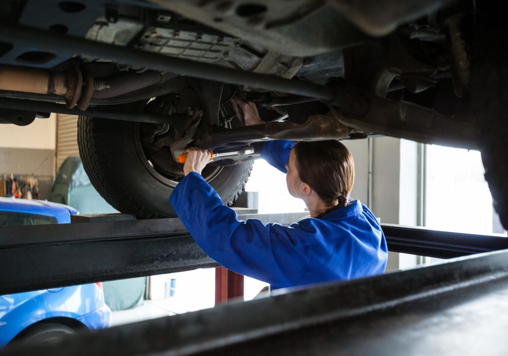 Female mechanic servicing car at the repair garage