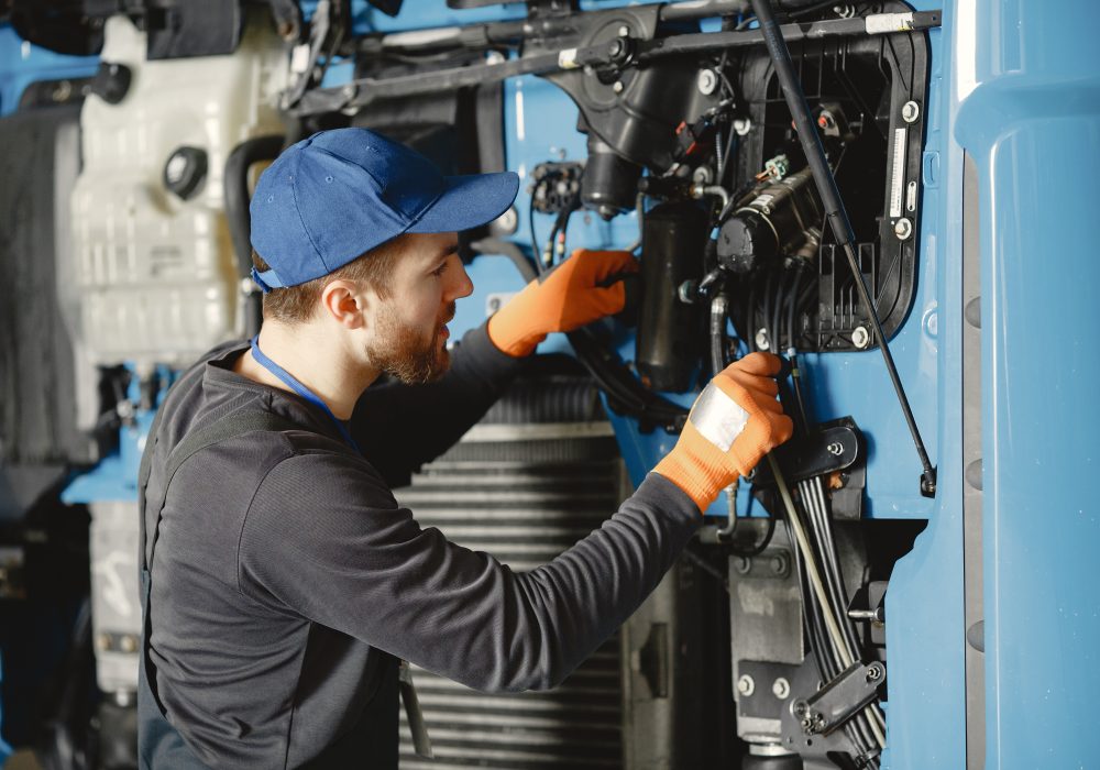 Man with tools for truck. Worker in uniform. Faulty truck