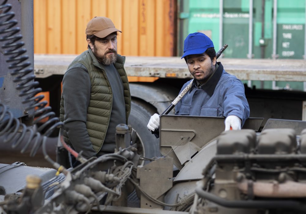 medium-shot-men-looking-inside-truck
